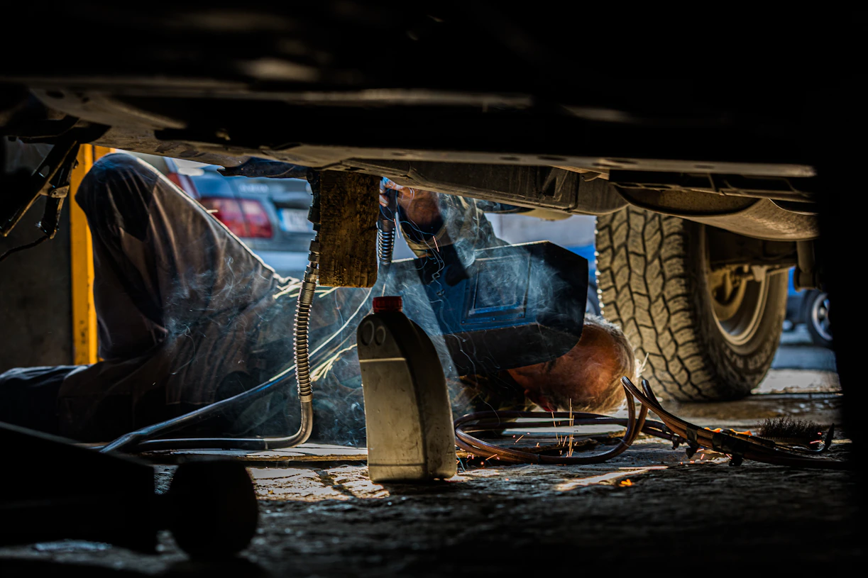 person fixing under vehicle part