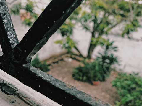 Detail of a custom metal railing with green painted elements in a residential garden.