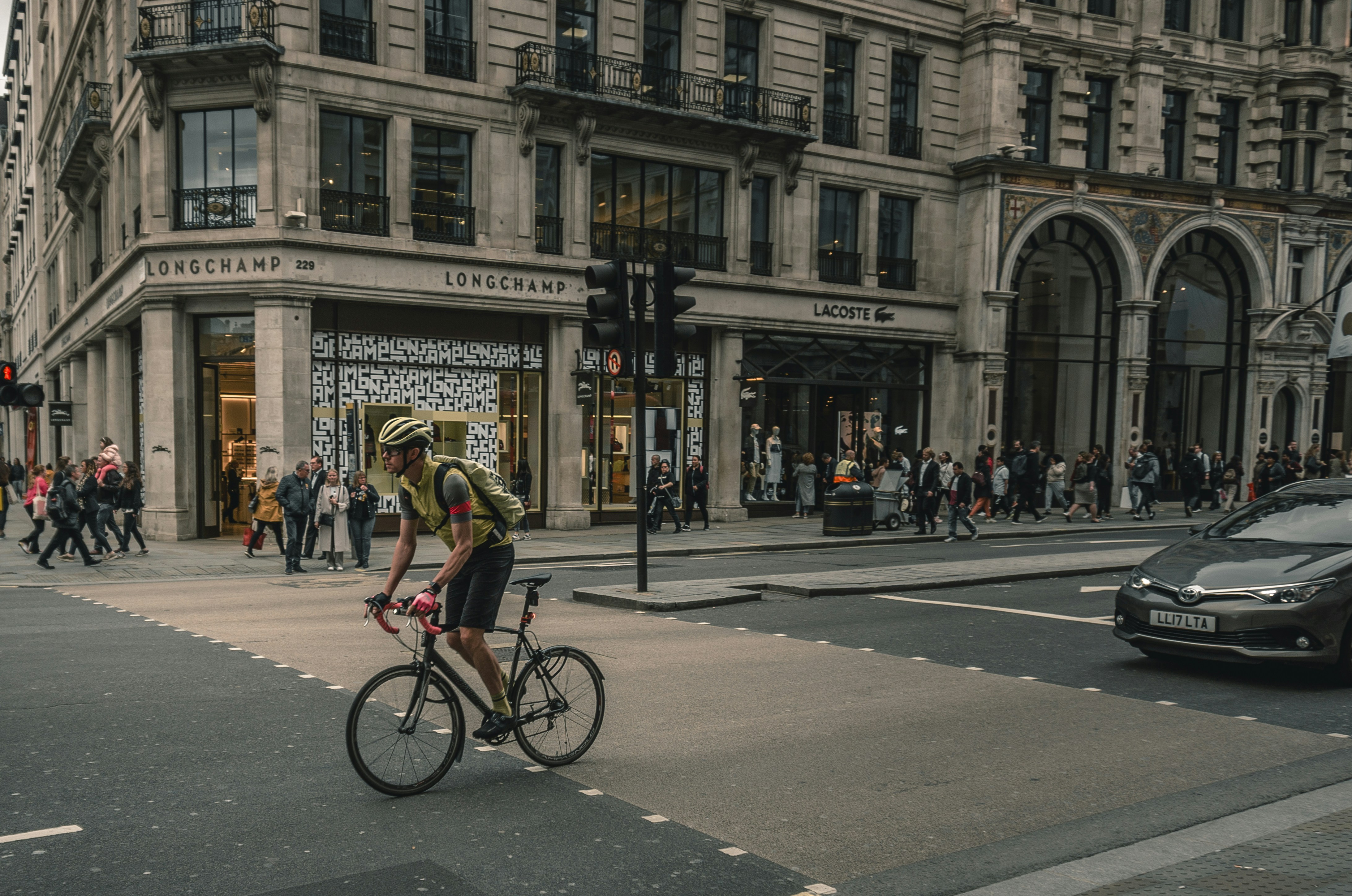 man riding bike on road in front of vehicle