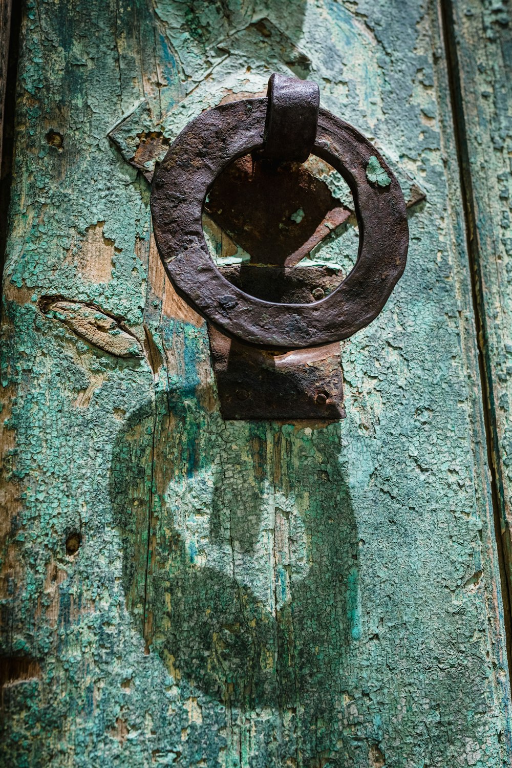 a rusted metal door handle on a wooden door