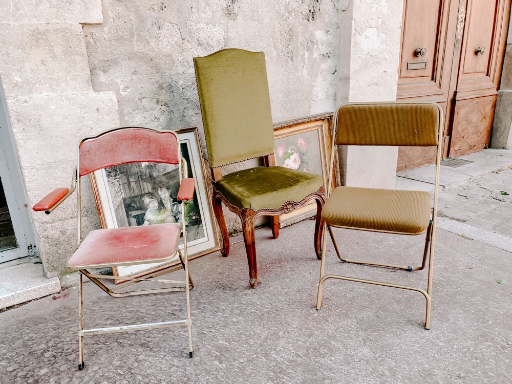 três cadeiras acolchoadas de cores variadas
