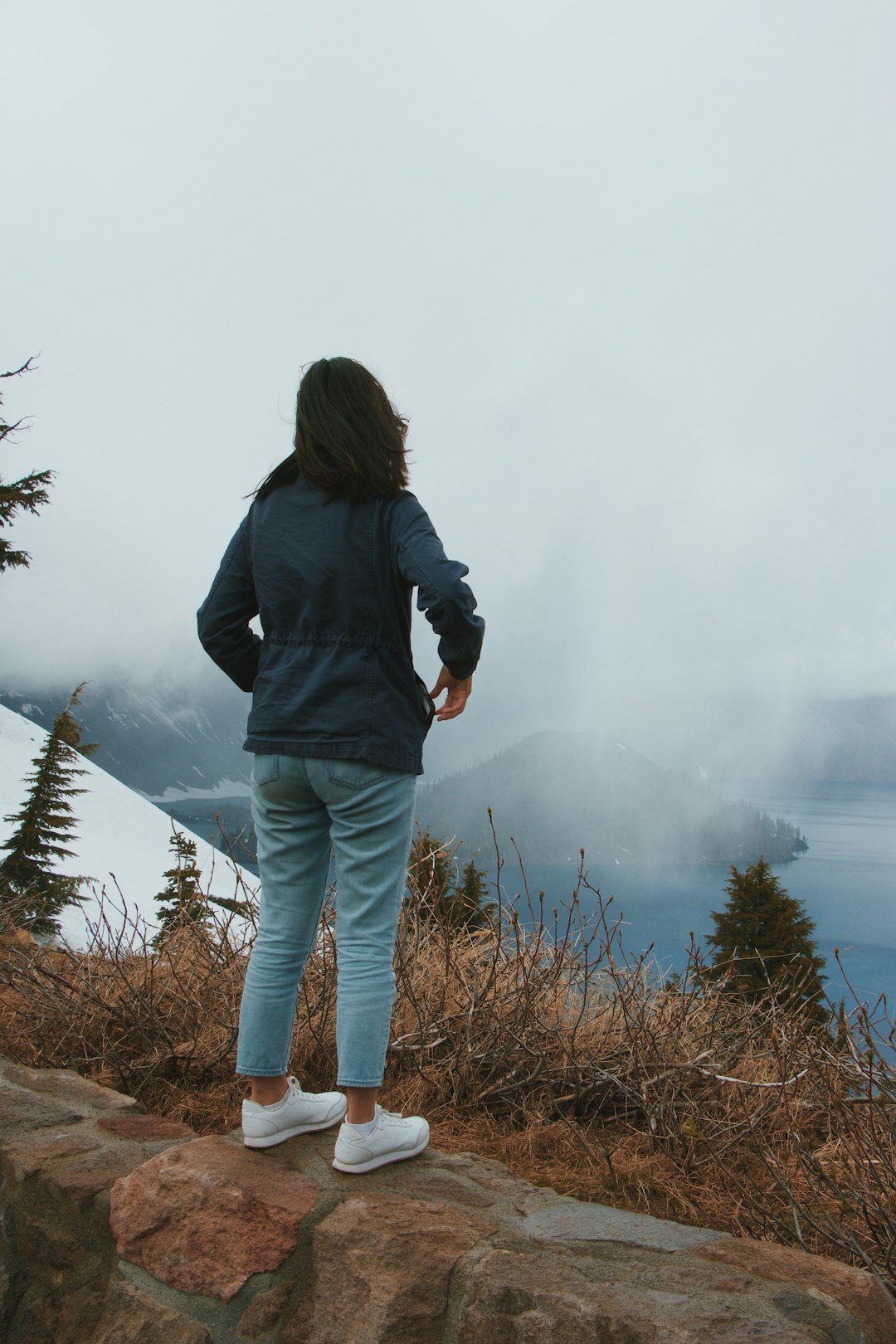 woman in blue standing on a rock