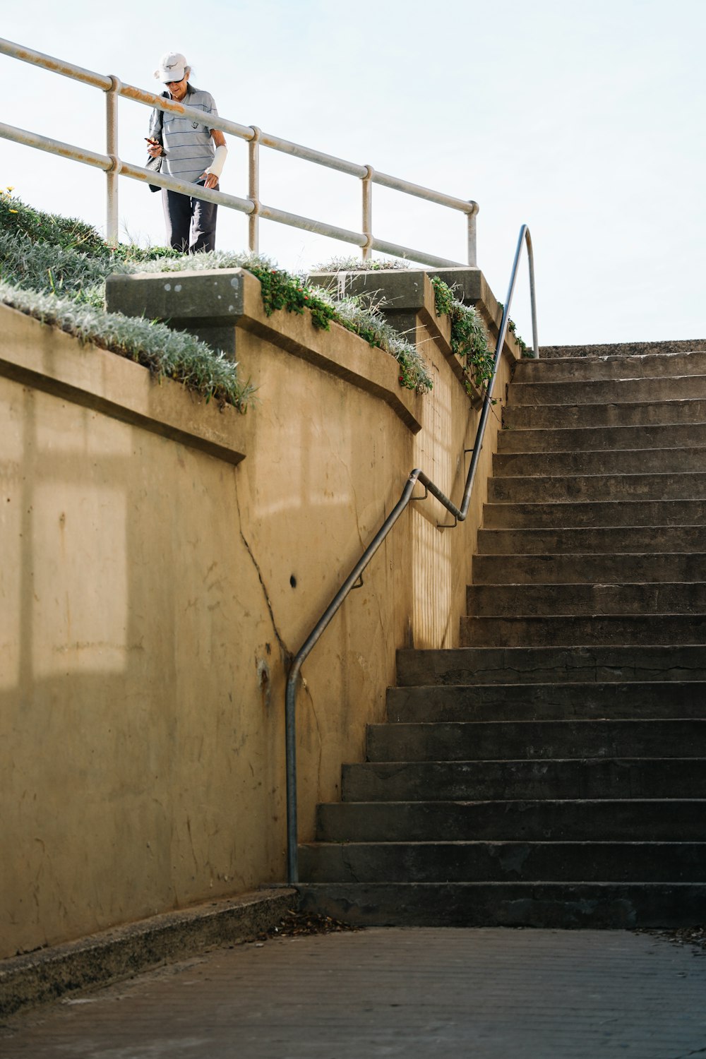 man walking beside gray metal railing