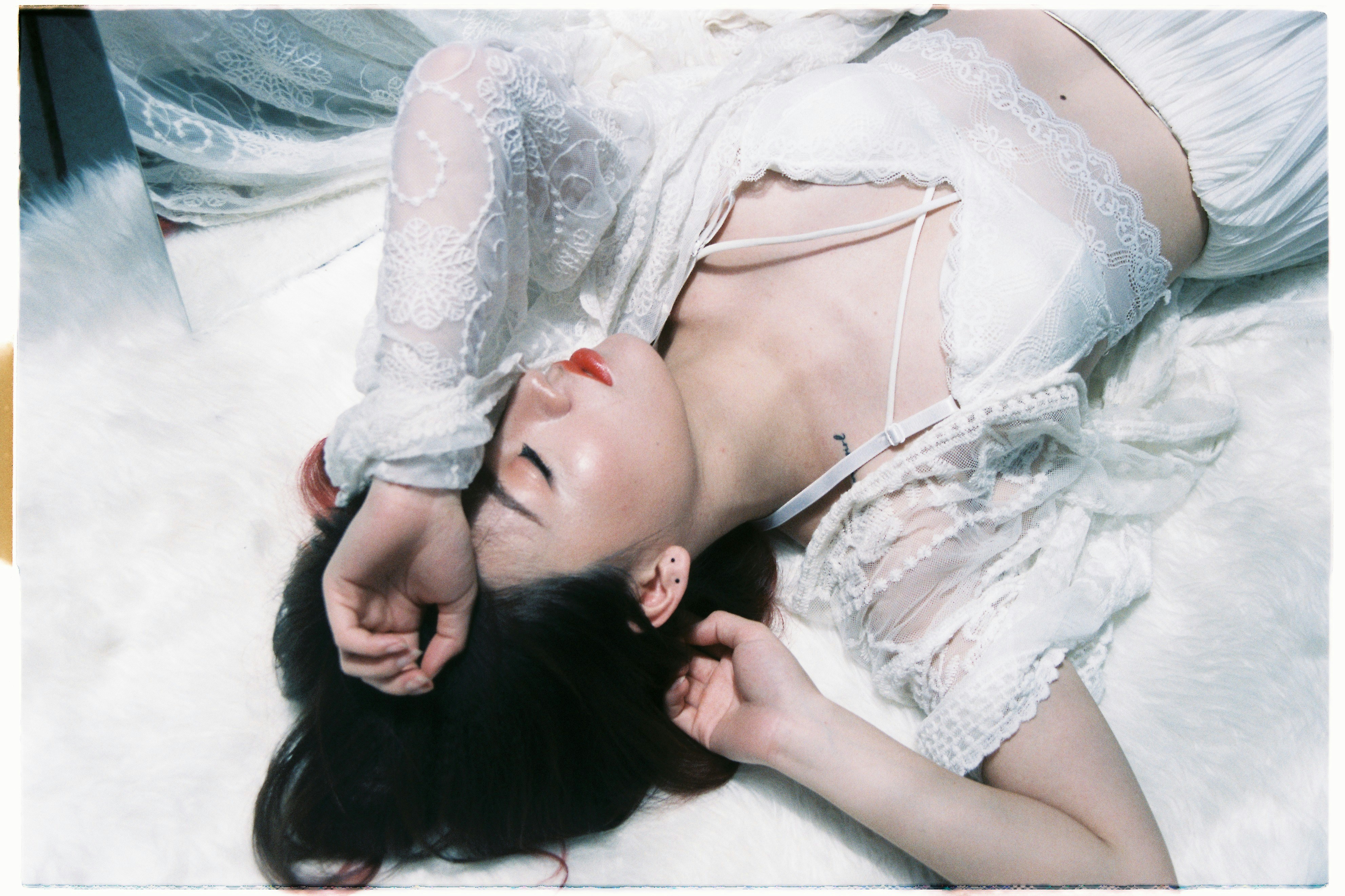 woman lying on white textile