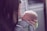 A close-up view of a person gently holding a newborn baby. The person leans in closely, tenderly touching the baby's forehead with their own. The baby, wrapped in a blanket, is peacefully sleeping.