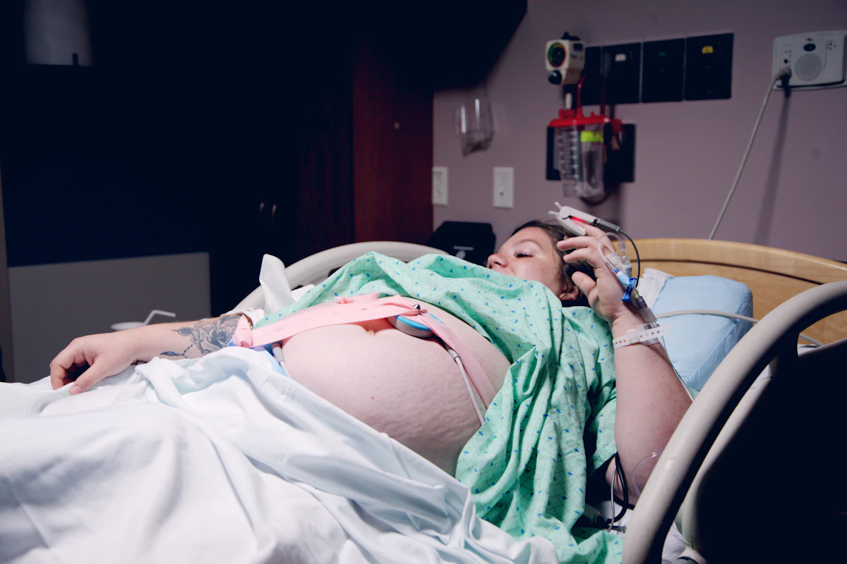 Pregnant woman lying in a hospital bed during labor, connected to a fetal monitor
