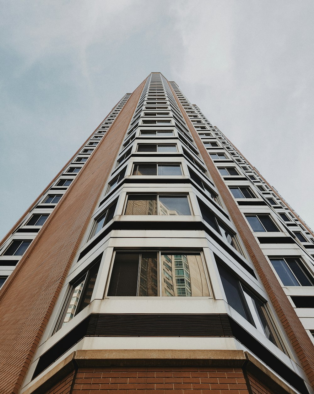 brown and white concrete building under white clouds during daytime