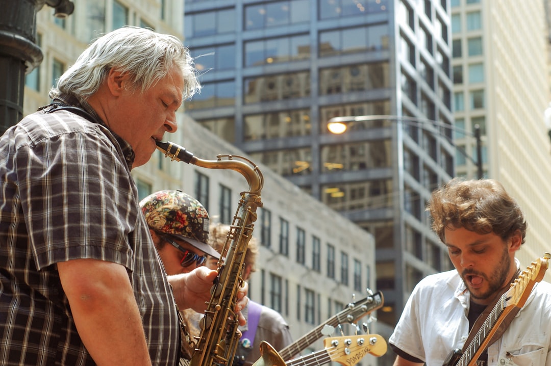 group of men playing individual wind instruments near high-rise buildings