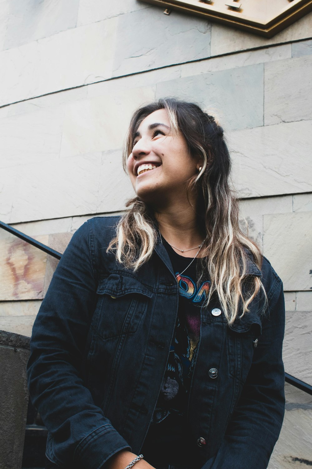 woman in black denim button-up jacket smiling