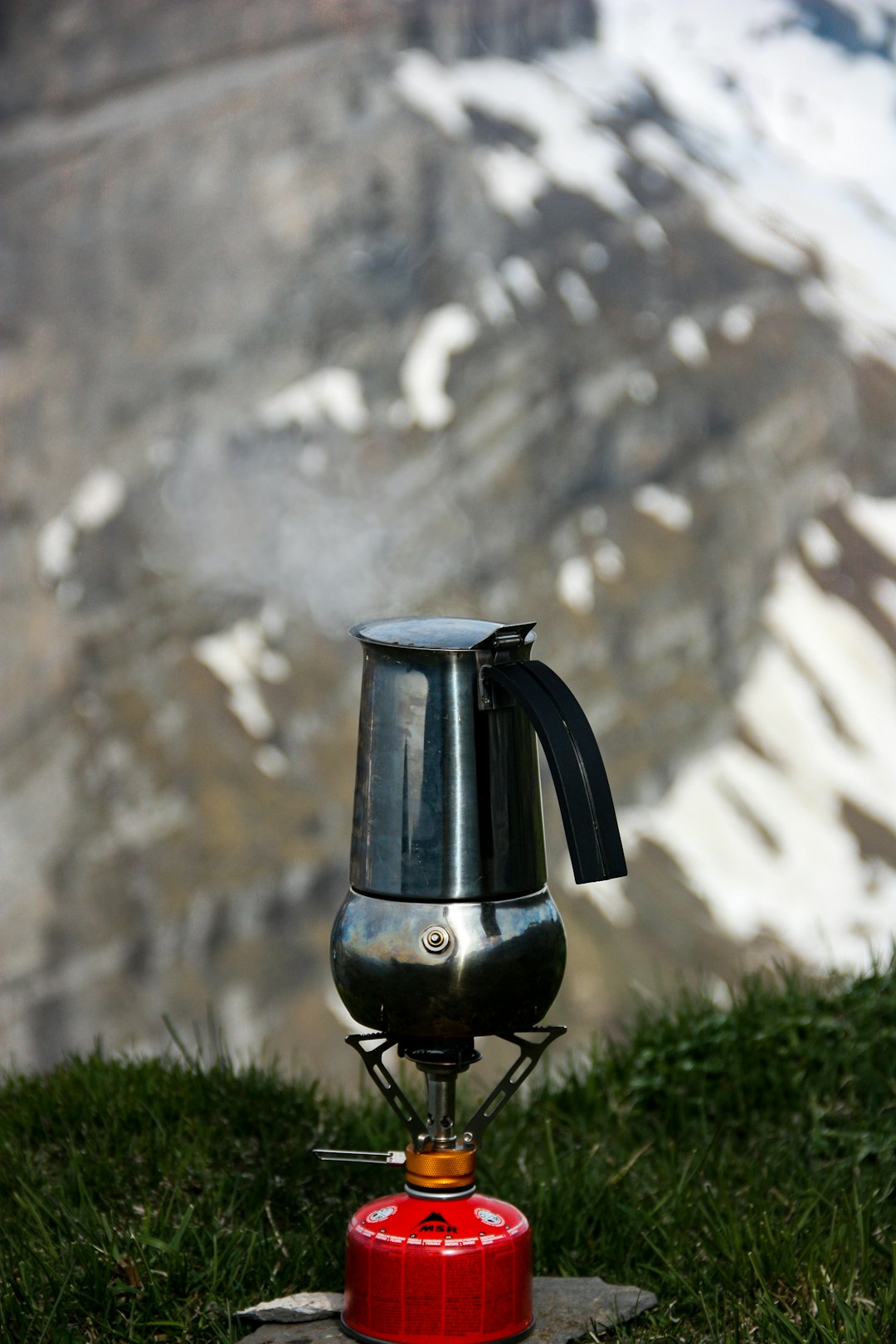 stainless steel kettle on red portable kerosene camping stove