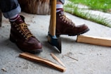Firefighter boots standing ready beside a bright red fire axe.
