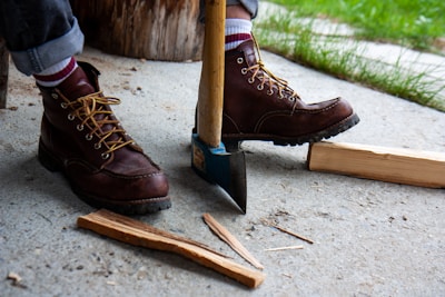 Firefighter boots standing ready beside a bright red fire axe.