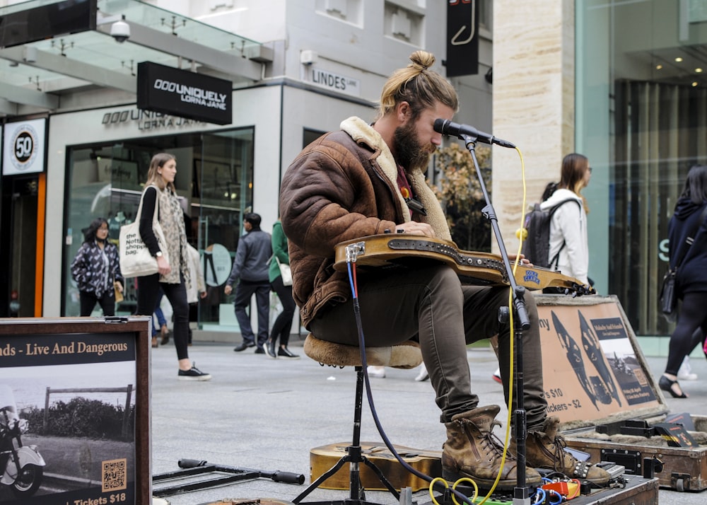man playing musical instrument on street