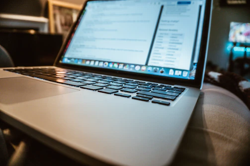 A laptop screen displaying outreach scripts with notes and highlights, set in a cozy home office.