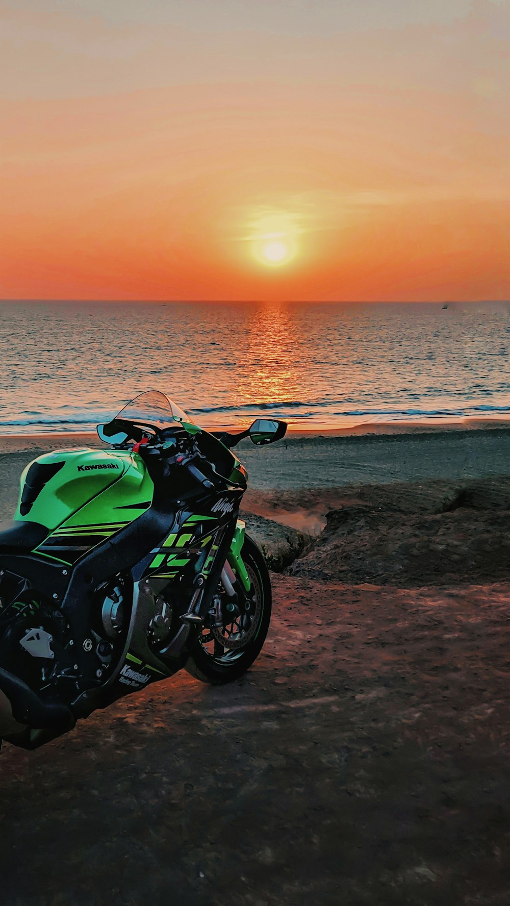 Kawasaki Ninja verde y negro junto al mar