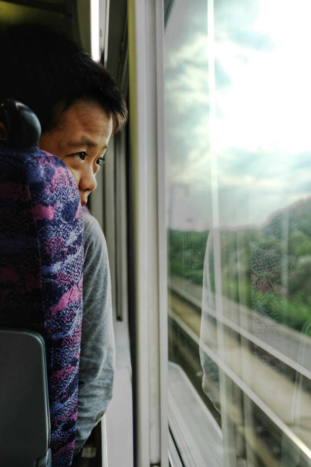 a man sitting on a train looking out the window