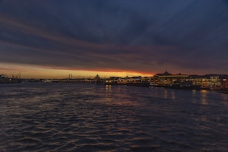 A romantic sunset view of Copenhagen's waterfront with the city lights beginning to twinkle.