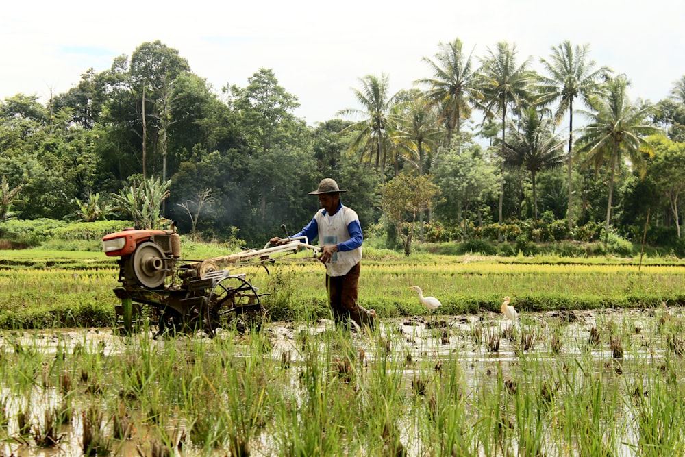 a man is plowing a field with a tractor