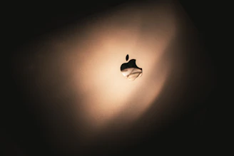 A close-up shot of a sleek Apple Silicon chip glowing softly against a dark background.