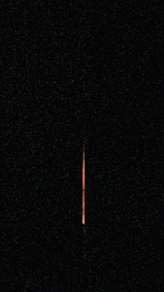 Close-up of a V16 beacon with vibrant orange light against a black background