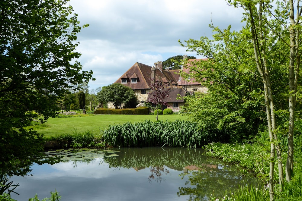 landscape photo of a brown stone building by a pond