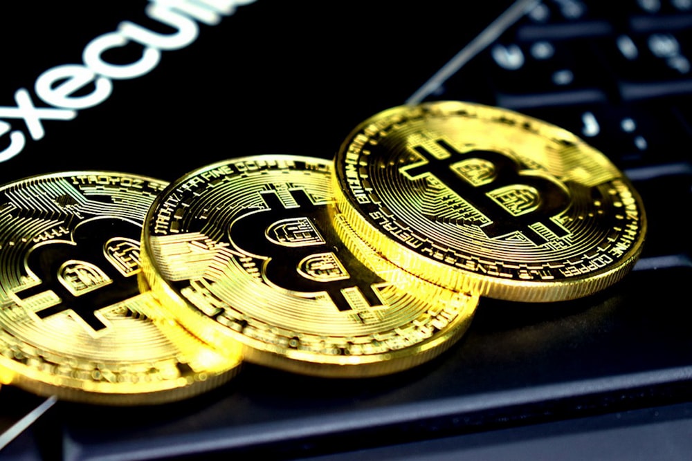 three round gold-colored bitcoins