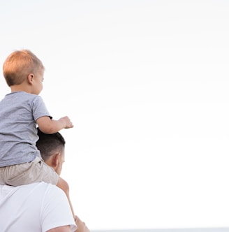 man in white shirt carrying boy