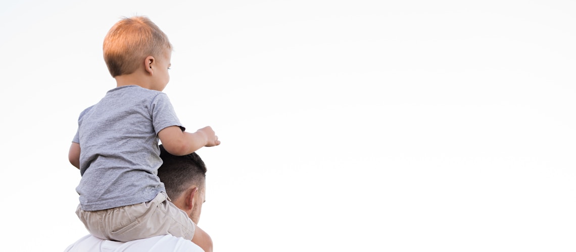 man in white shirt carrying boy