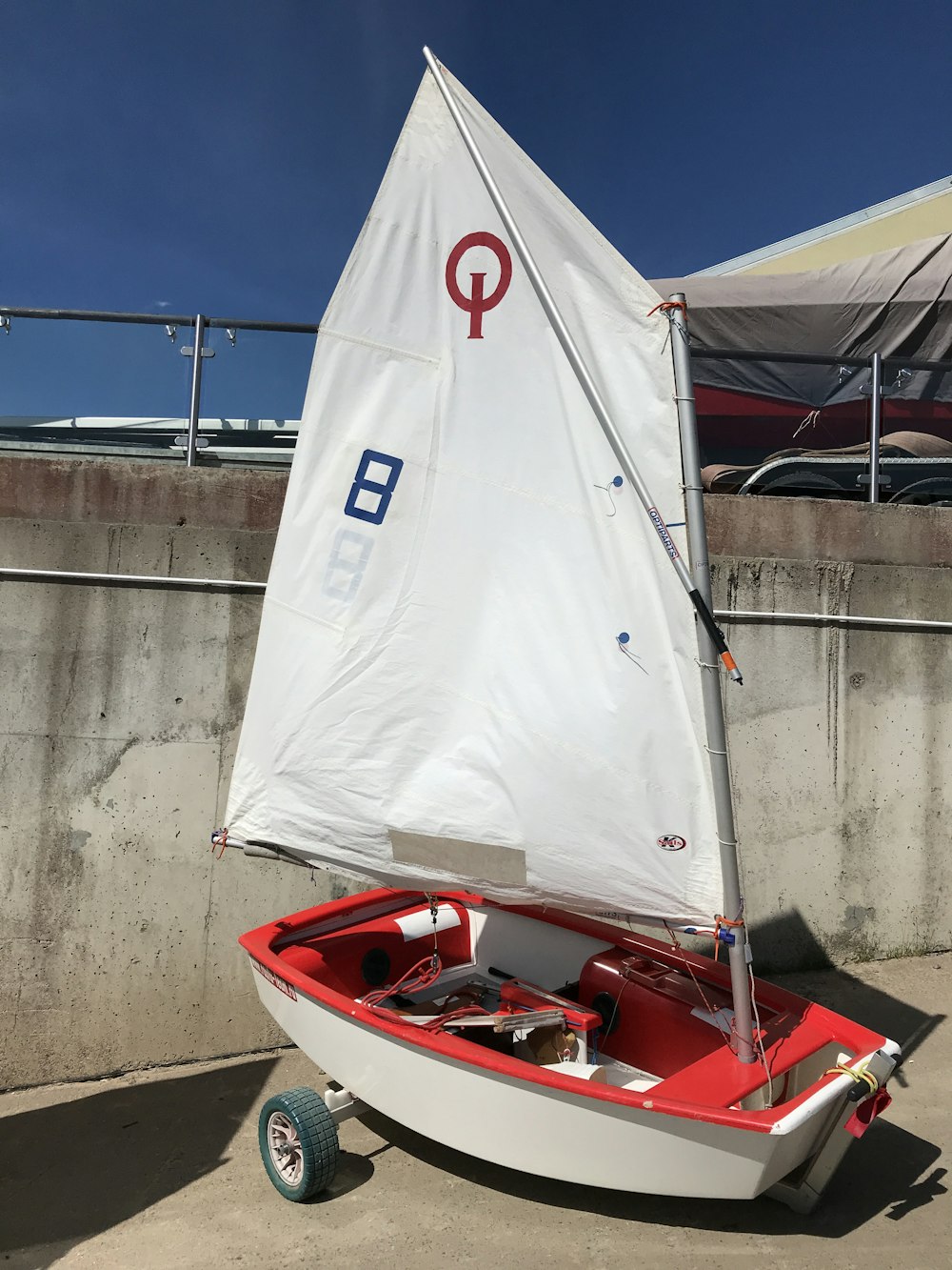 a small sailboat is parked on the concrete