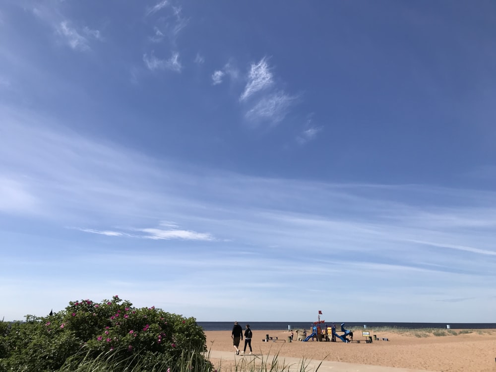 Gruppe von Menschen, die am Strand unter klarem blauem Himmel spielen