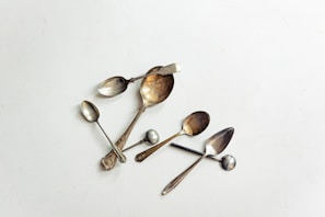 A charming display of handcrafted souvenir spoons arranged on a vintage tray.