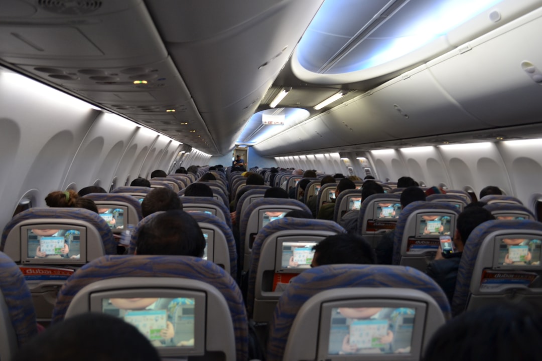 a view of the inside of an airplane with people playing video games,