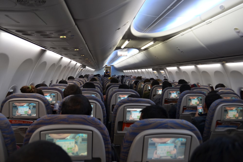 a view of the inside of an airplane with people playing video games