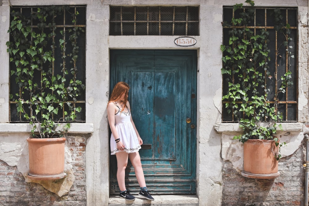 woman leaning on wall during daytime