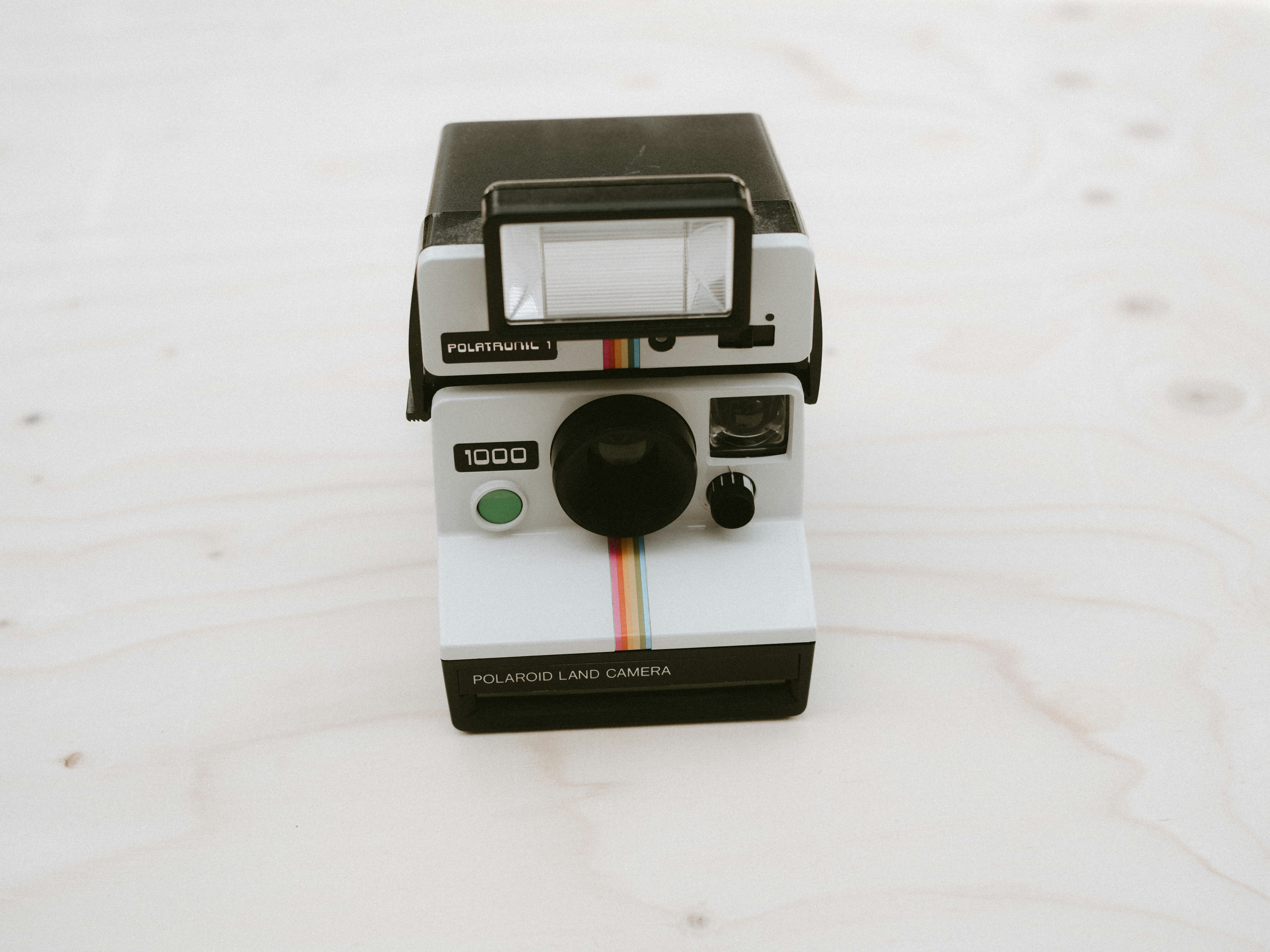 Vintage Polaroid camera on warm wooden surface with soft natural light