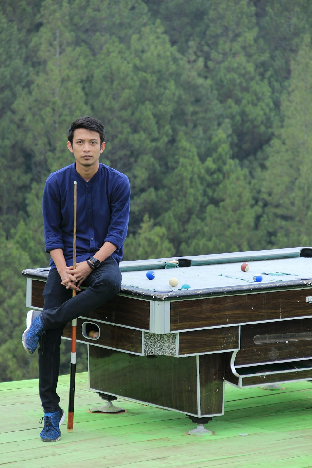 man sitting on billiard table