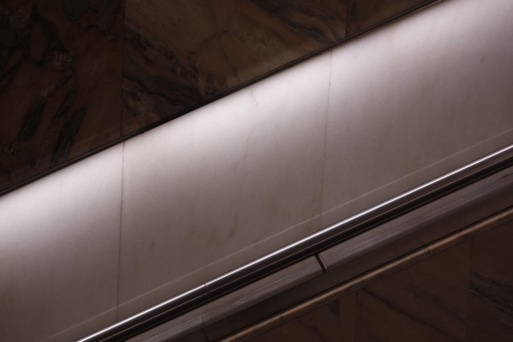 an escalator in a building with a metal handrail