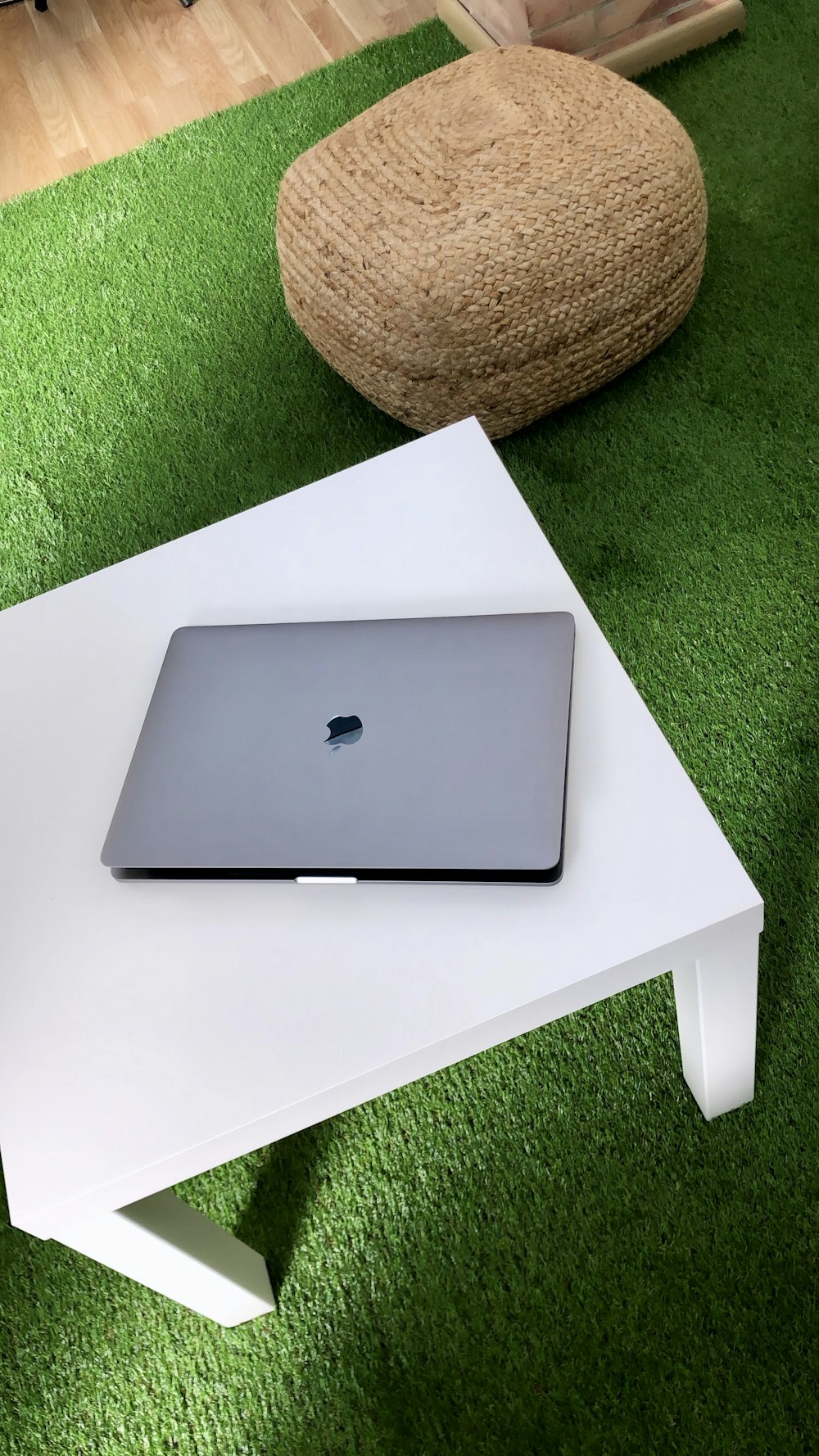 closed silver MacBook on white table