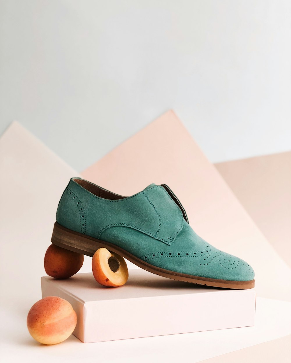 unpaired green leather shoe on top of white box