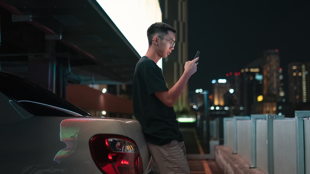 man leaning on grey vehicle