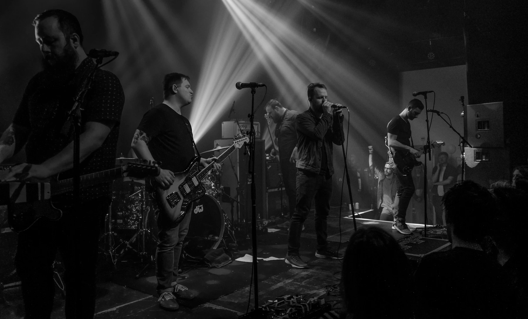 Band performing live beneath dramatic stage lights