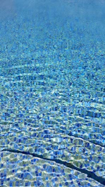 Close-up of sparkling blue water with clean tiles and clear reflections.
