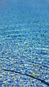 Close-up of sparkling blue water with clean tiles and clear reflections.