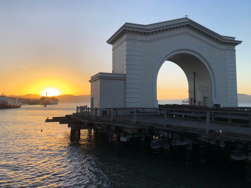 Arco de hormigón blanco y pasarela de madera marrón