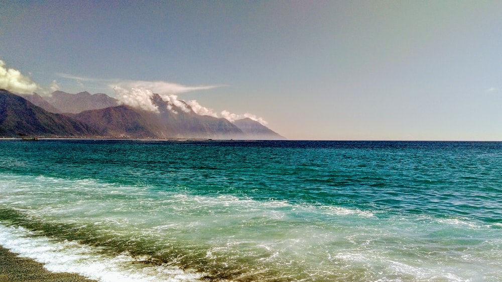 a view of the ocean with mountains in the background