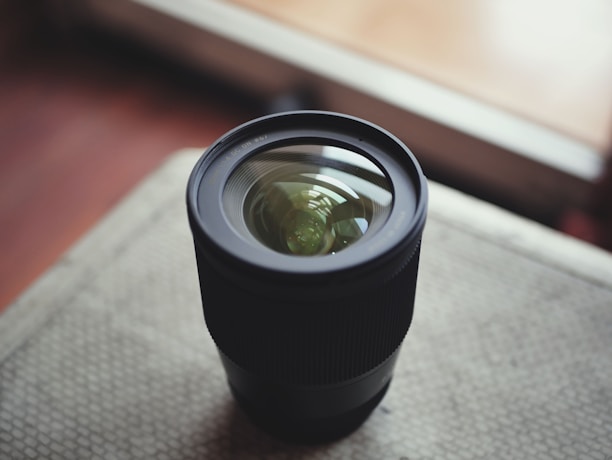 Close-up of a camera lens reflecting soft natural light, symbolizing the precision and care of Studio Palmas.