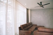 brown couch and black celing fan