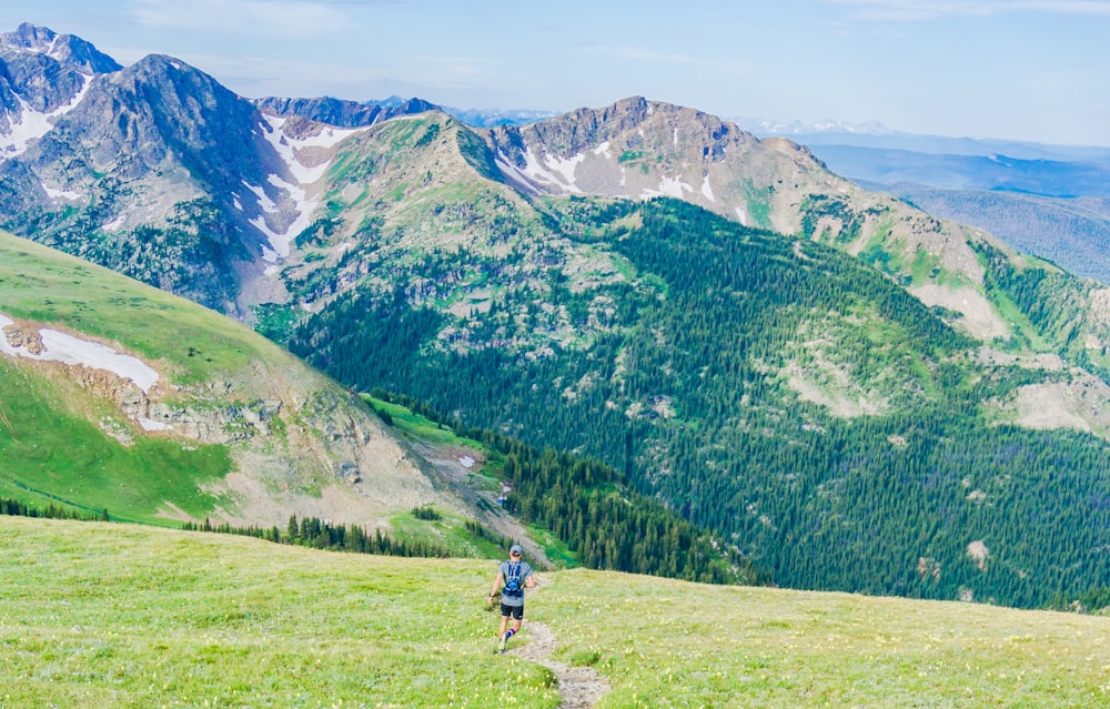 man walking on walkway facing mountains