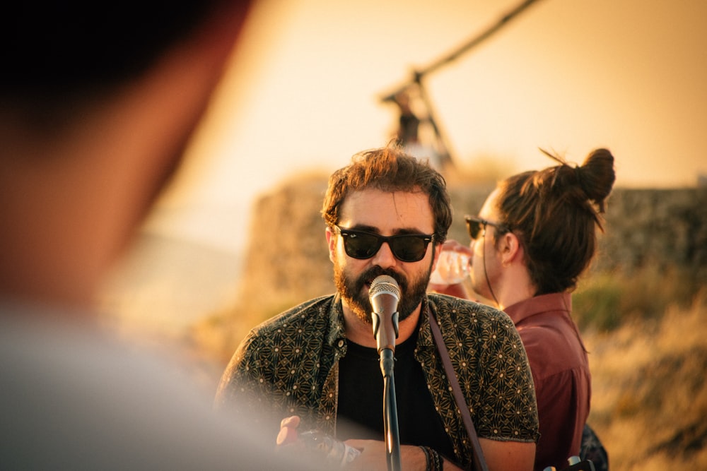 man wearing black sunglasses on microphone