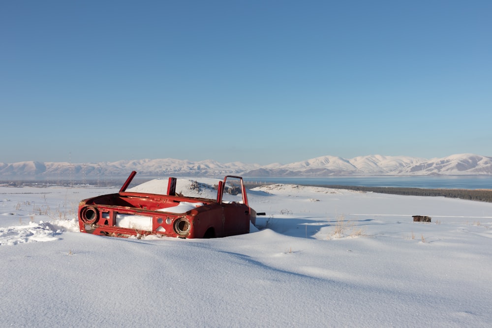 red wrecked car in the middle of ice surface